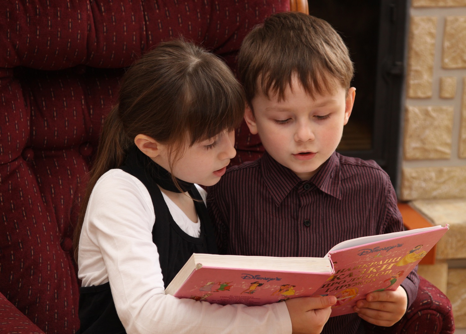 To børn læser i en bog sammen