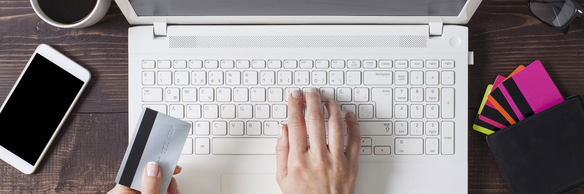 to hænder med et kreditkort som taster på en bærbar Computer