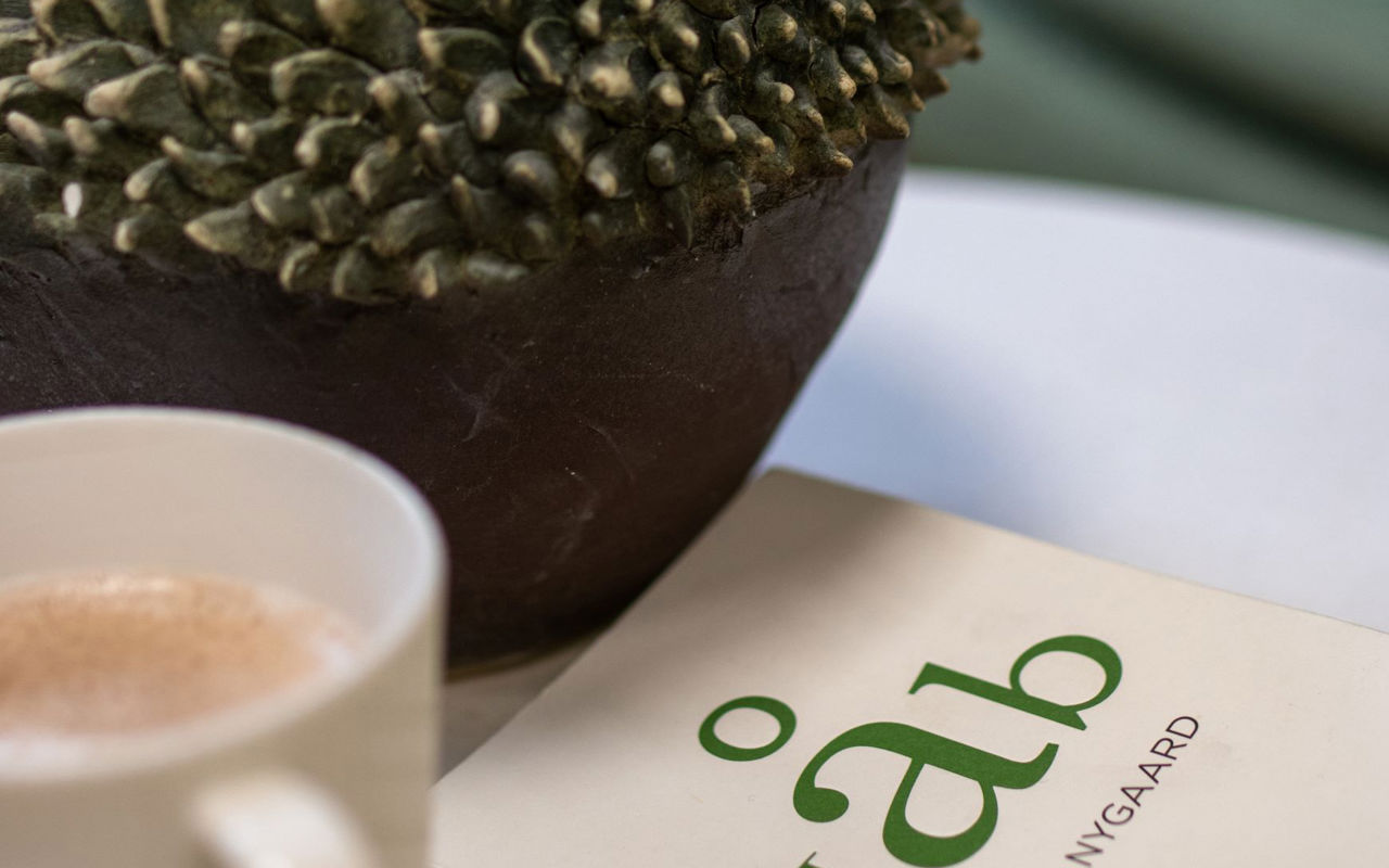 Venteområde med en kop kakao og bogen håb